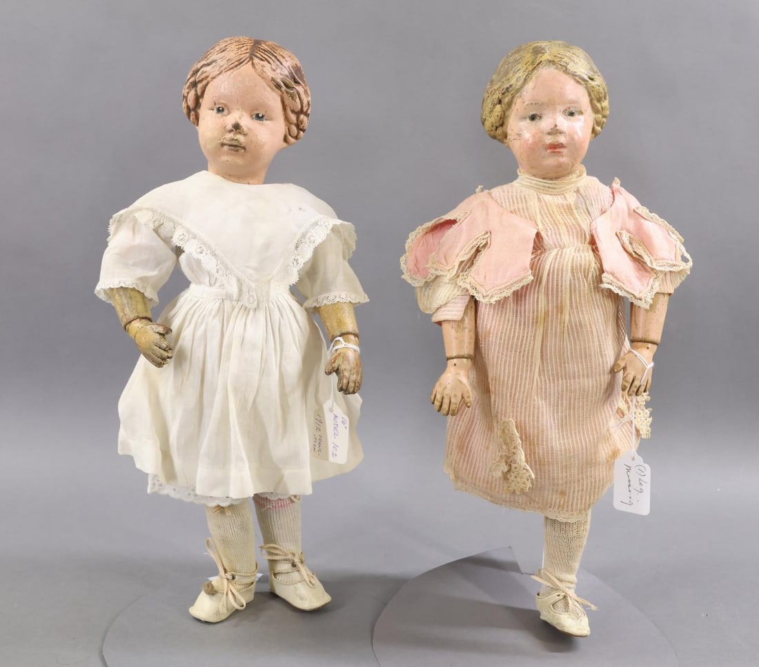 SCHOENHUT.: Pair of 16" Model No. 102 Schoenhut dolls with carved heads. These are 1912 transition dolls. They have the incised mark on the back of the torso. They both have the carved braids with a blue bow on