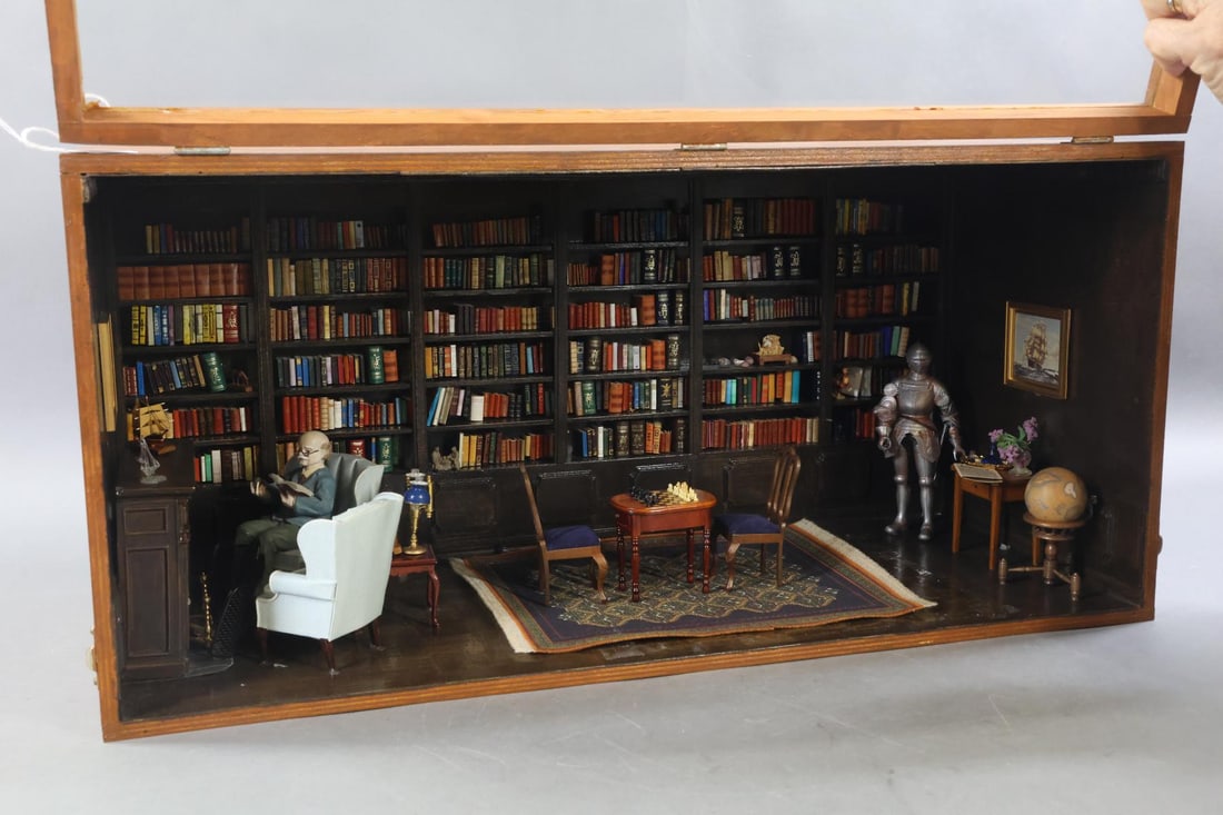 ROOM BOX.: LIBRARY Room Box. Contemporary scene of man sitting in front of fireplace reading a book in his library. Entire back wall covered with bookcases filled with volumes of books. He is sitting on blue