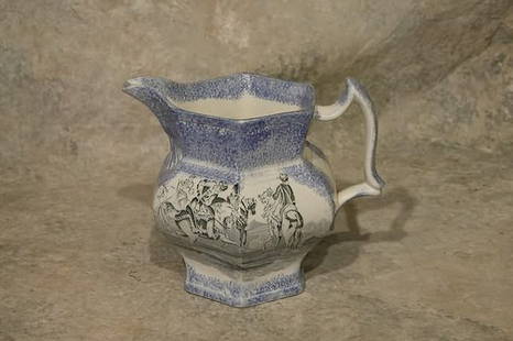 Sponge and Transfer Decorated Pitcher.: Blue sponge decorated rim and base with black transfer design of men on horseback. 6 1/2" t. Condition: Hairline, flake.