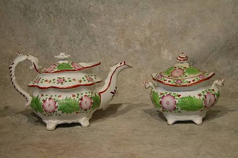 Soft Paste Tea Pot and Sugar Bowl.: Squat tea pot form decorated with pink flowers and large green leaves. 7 1/2" t. Sugar bowl 6" t. Condition: Flakes on lid and spout of tea pot, sugar bowl has wear on rim and flakes on interior rim