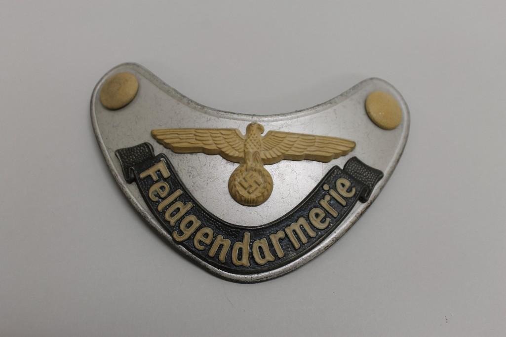 German WW II "Feldgendarmerie" Army Field Police: German WW II "Feldgendarmerie" Army Field Police gorget. Lot consists of a stamped metal kidney shaped plate displaying a large spread wing Army eagle above a grey painted tally presenting t