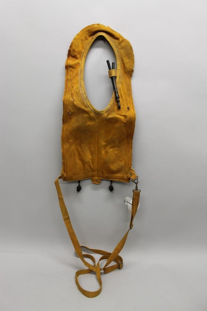US WW II Army Air Force life vest.: US WW II Army Air Force life vest. Vest complete with straps is made of yellow rubberized canvas equipped with two pull tabs actuating compressed gas cannisters and back-up mouth tubes for blowing up 
