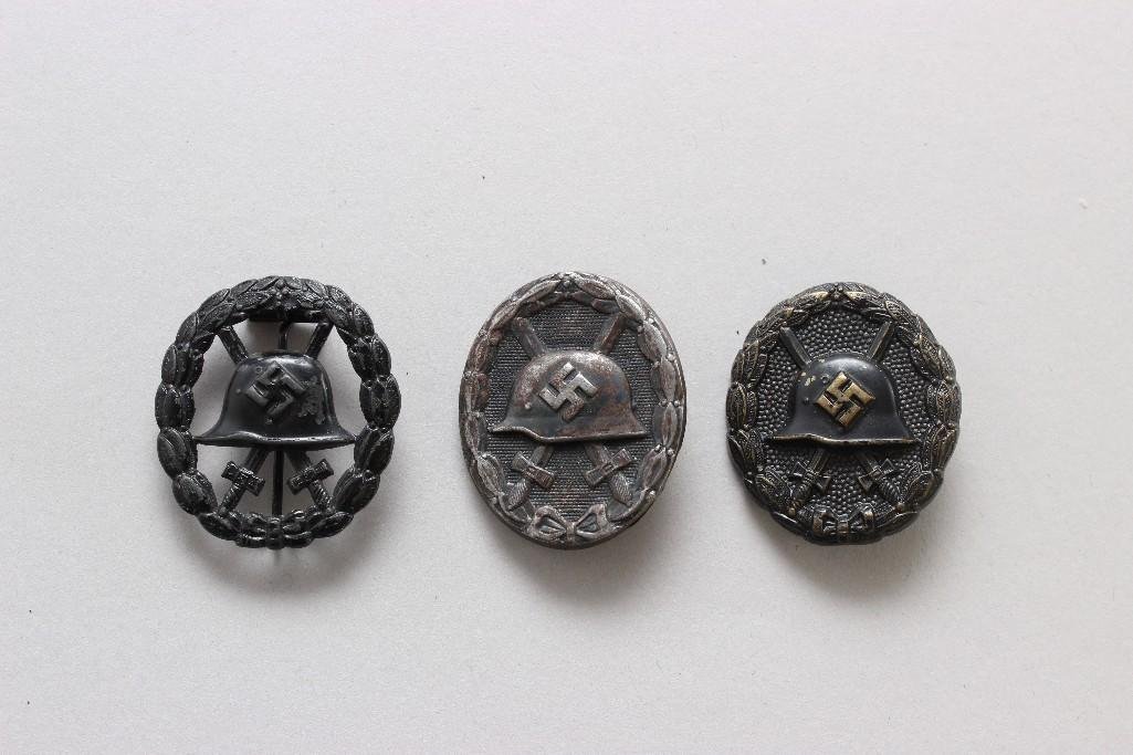German WWII Black Wound Badges: Grouping of three German World War II black wound badges (one cut out, one maker marked "32" on reverse)