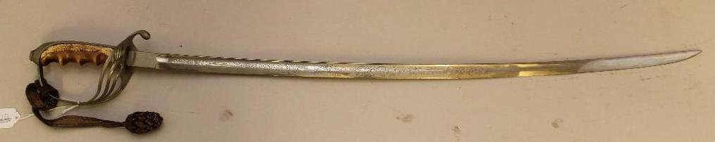 Model 1902 US Officer's Sword: Model 1902 US officer's sword featuring bone grip manufactured by the MC Lilley company, Columbus, OH. Sword featured etched blade. Sword features chromed scabbard with handle presenting original bull