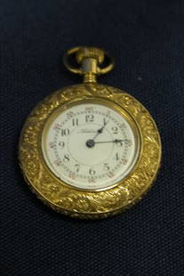 Pocket Watch.: Addison Co., numbered dial, decorative case depicting country home. Open face. Various patent dates 1878-1884. Case in 10K yellow gold.