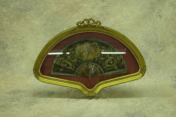 Hand Painted Fan.: Tortoise shell type with pierced gilt ornamentation, silk fan with hand painted medallions, romantic garden scene and instruments, floral swags and sequins. Fan, 8" x 16", in a fitted frame of gilt ge