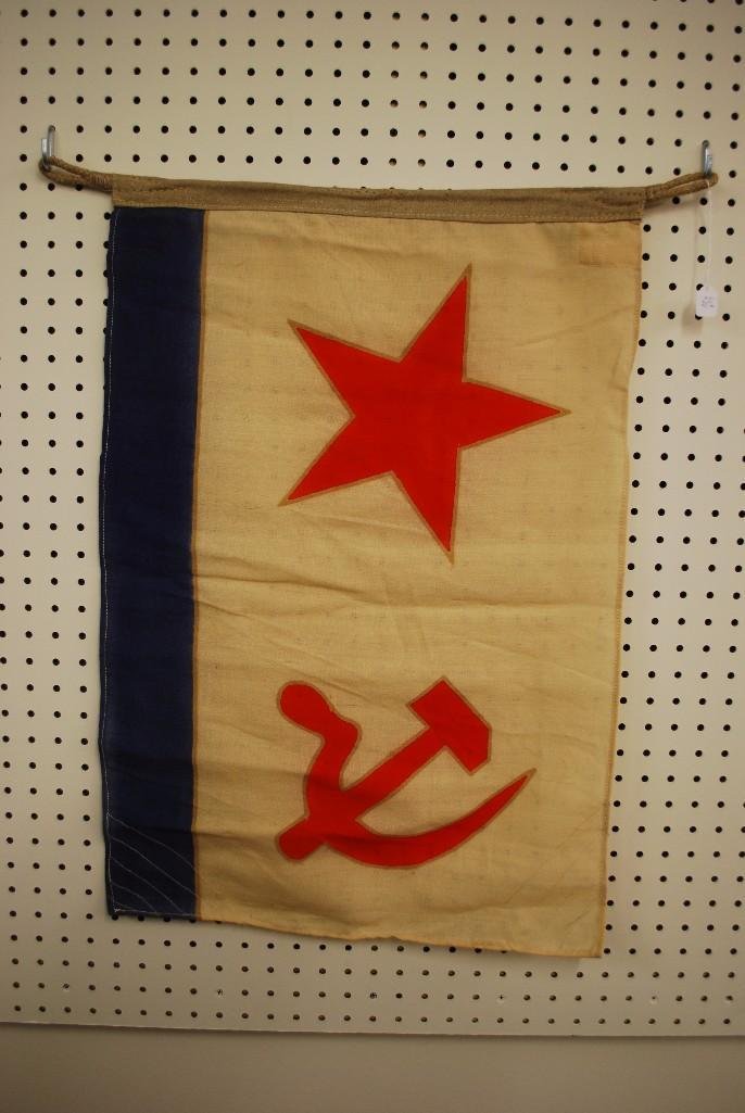 Naval Ensign of the Soviet Union: Small naval ensign of the Soviet Union presenting a red star and red sickle/hammer on white field with blue border at bottom. Ensign present rope hoist, measures 18.5" x 26" and exhibits som