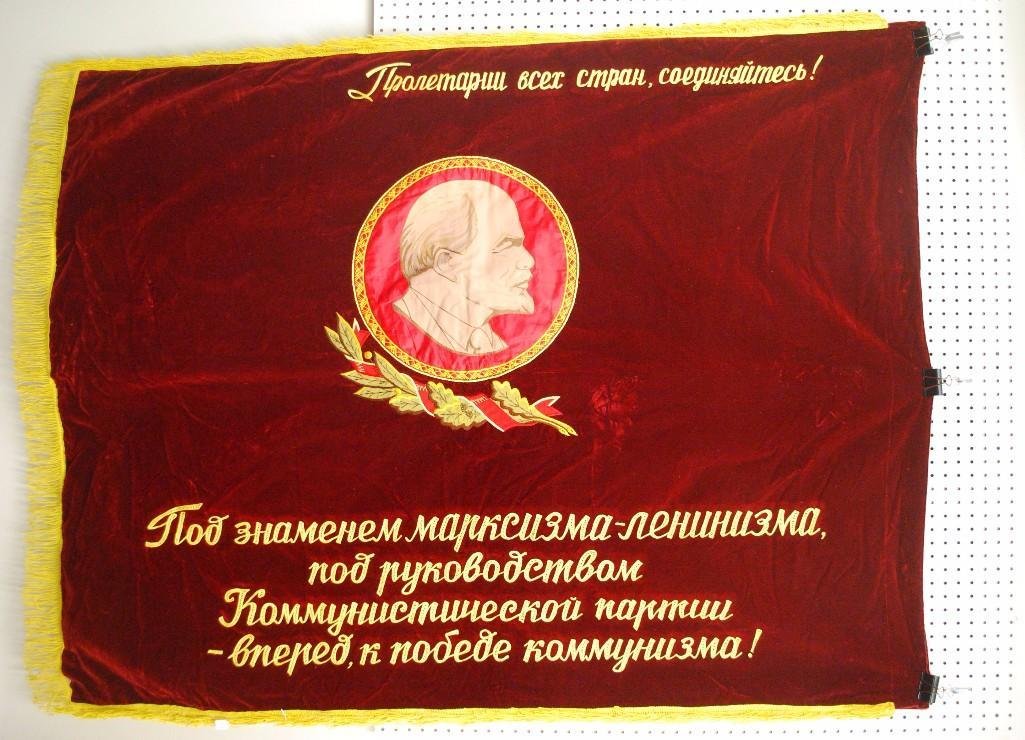 Soviet Flag: Heavy velour Soviet flag with machine embroidered lettering and paint/ink/machine embroidered seal. Flag features seal of Soviet Union on obverse with bust portrait of Lenin on reverse. Flag measures 