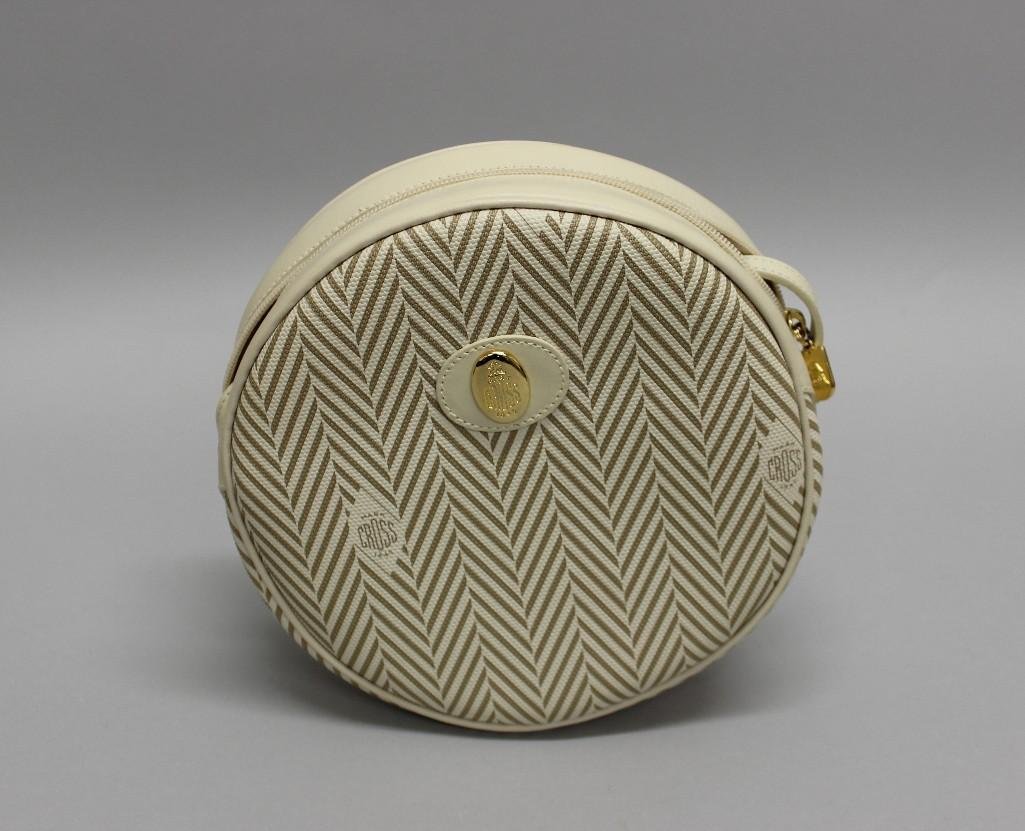 Mark Cross Round Crossbody Bag: Signature cream/tan herringbone coated canvas round bag with top zip closure, gold toned hardware, and thin shoulder strap. Leather lined interior features side zip pocket. Marked "Mark Cross New