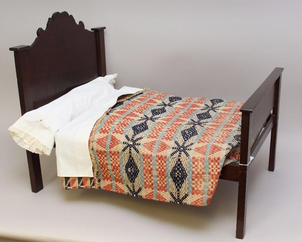 ANTIQUE WOODEN DOLL BED WITH BEDDING. (1 of 2)