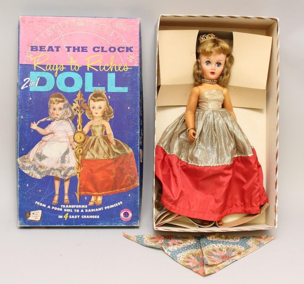 19" ALL ORIGINAL 1957 VINYL "BEAT THE CLOCK - RAGS TO: This is an original owner doll. Vinyl fashion doll with blue sleep eyes, honey blonde hair. Dressed in gold lame Princess gown, crown and high heel shoes. Reverses to patchwork Poor Girl dress and ban