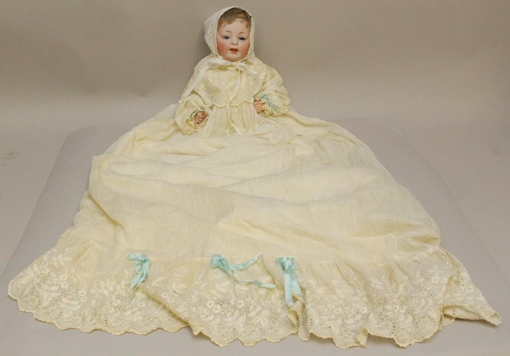 15" H. MADE IN GERMANY 12. 211 JDK ANTIQUE BISQUE HEAD: 11 3/4" Cir. head with blue sleep eyes, open/closed mouth, blonde mohair wig, plaster pate. 5 Pc. papier mache bent limb baby body. Dressed in antique white cotton long gown trimmed with hand emb