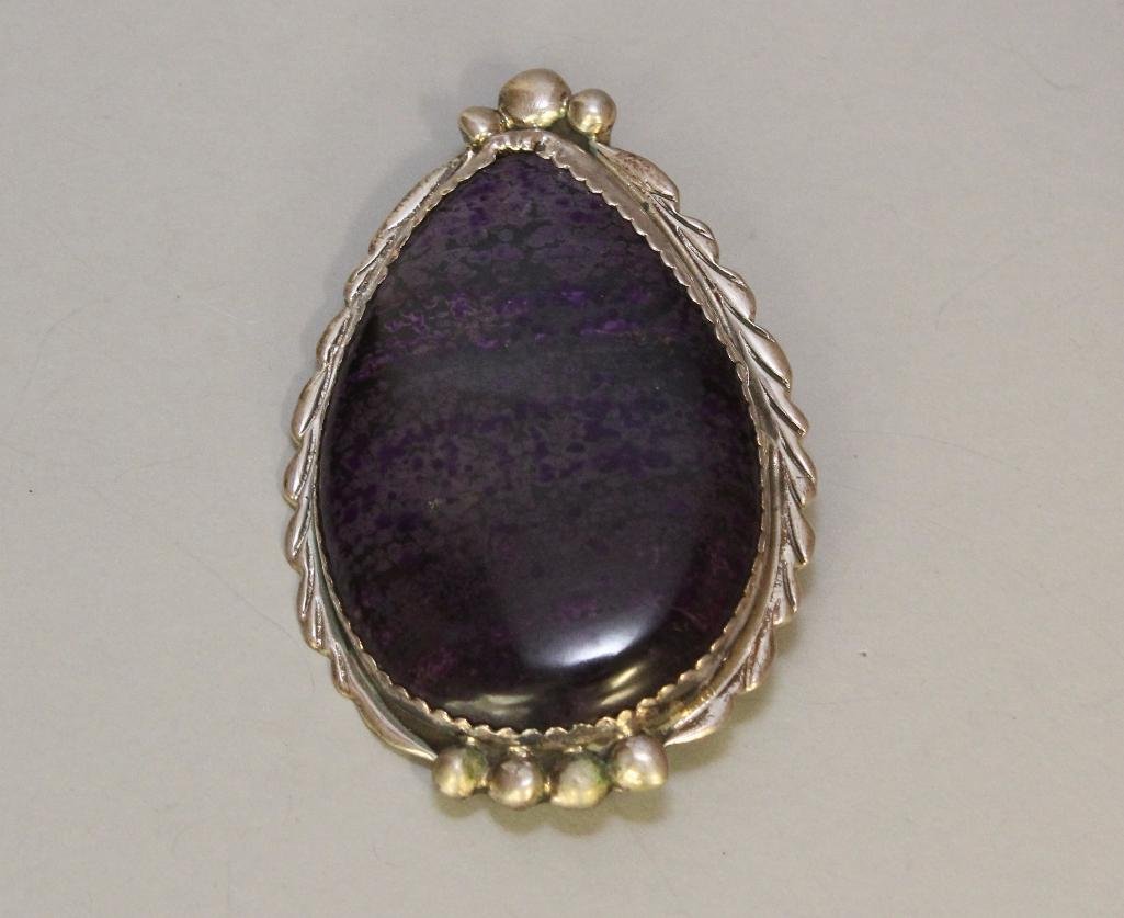Native American Sugilite Pin: 2 1/2" x 1 1/2" sugilite stone cabbed in silver. Signed by the artist on the back. 