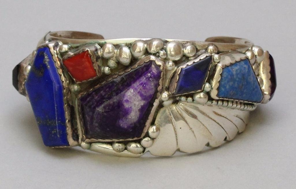 Native American Cuff Bracelet: Sterling silver with semi-precious stones including lapis, sugilite, turquoise and coral. Signed by the artist.