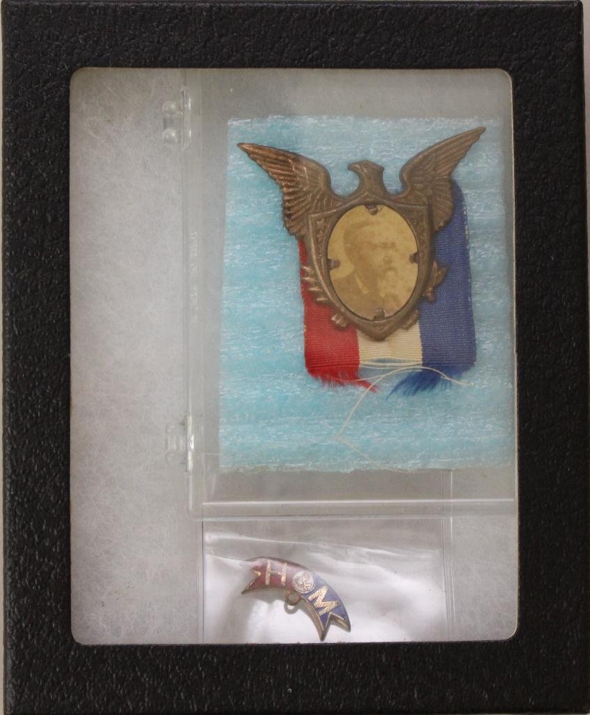 Presidential Political Badge- Benjamin Harrison-1888: Stamped tin political badge in the shape of a spread winged eagle featuring albumin photograph of bust view of Harrison on shield. Badge backed by small red, white and blue ribbon. Eagle measures 1.5&