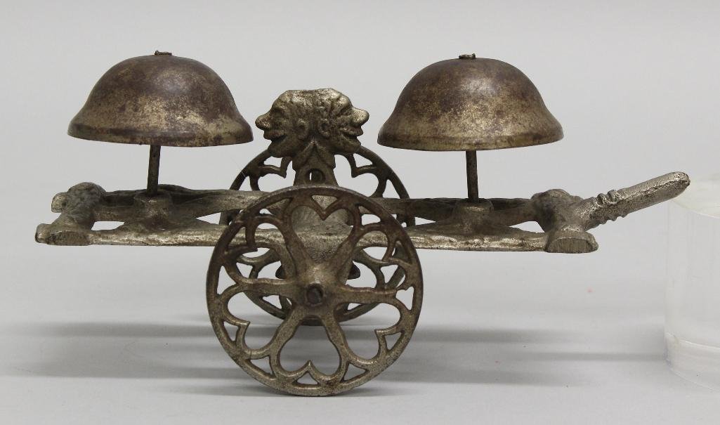 Two Faces, Cast Iron, Bell Toy: Cast iron bell toy with double faced gong. With forward motion, gong moves back and forth, noses of faces ring the bells. Silver paint in good condition. 3.25"h x 6.75"w x 2.5"d