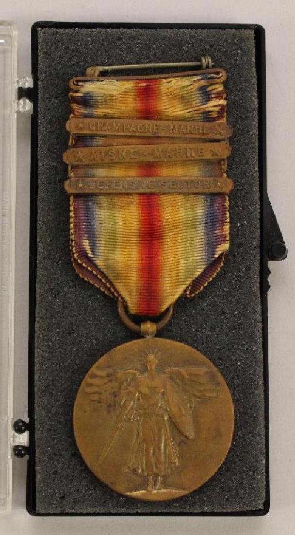 WWI Victory Medal-3 bars: United States World War I Victory medal with three battle bars including Champagne-Marne bar, Aisne-Marne bar, and Defensive Sector bar. Ribbon presents wear and some splitting.