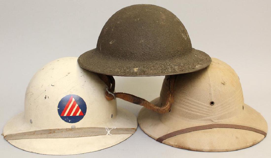 Grouping of Helmets: Grouping of helmets including; 1.) WWI helmet with sand paint, 2.) International Hat Co. 1948 dated sun helmet, 3.) Civil Defense helmet.