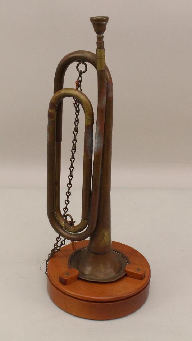 US Military Bugle: United States military bugle by Rexcraft. 20th century bugle marked "US Regulation" and presented on wooden base. Bugle presents some dents.