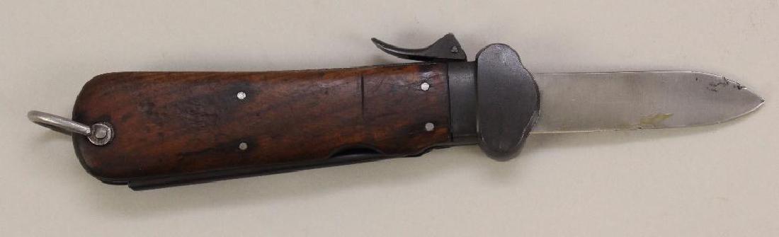 German Paratrooper Gravity Knife: German Paratrooper gravity knife with wood handles. Knife is serial numbered on interior "515". Knife measures 10" length (blade measures 4"). Spring of knife presents serial number "96".