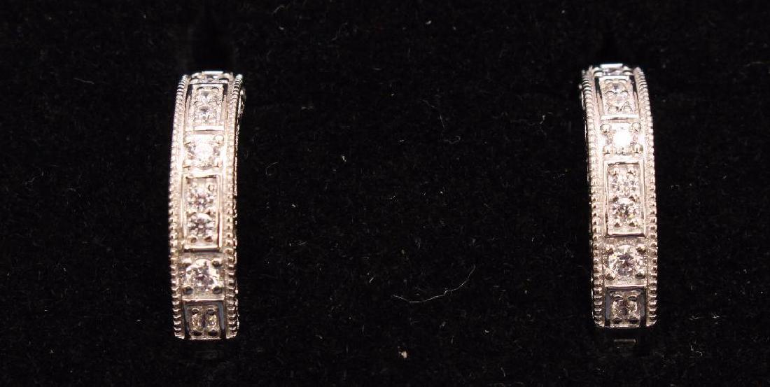 STERLING EARRINGS. XAVIER. HOOPS. CZ: ROUND CZS GO HALF WAY AROUND THE 3/4" FULL HOOPS. FILIGREE SIDES. HINGED WITH LOCKING POST.