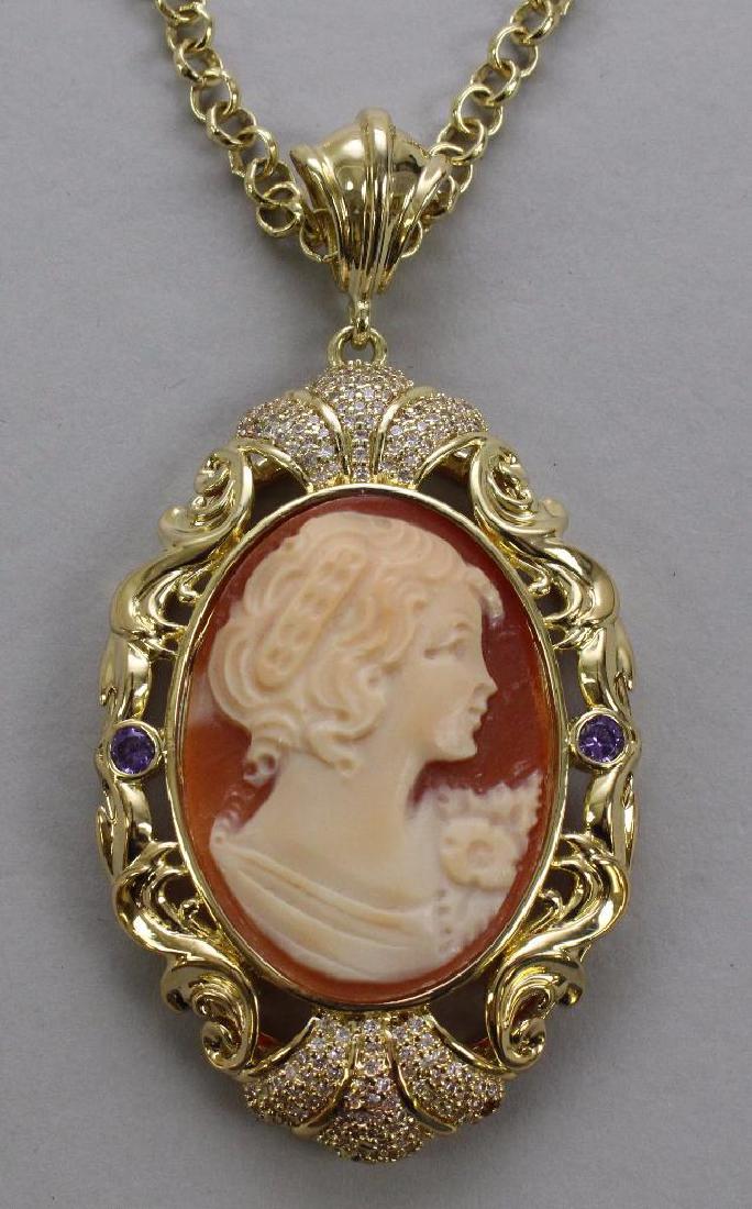 PENDANT ON CHAIN. AMEDEO. SHELL CAMEO: 40 X 30MM OVAL CAMEO. (2) FACETED ROUND AMETHYST SET EAST-WEST. CZ'S PAVE-SET NORTH-SOUTH. 24" LONG CHAIN.