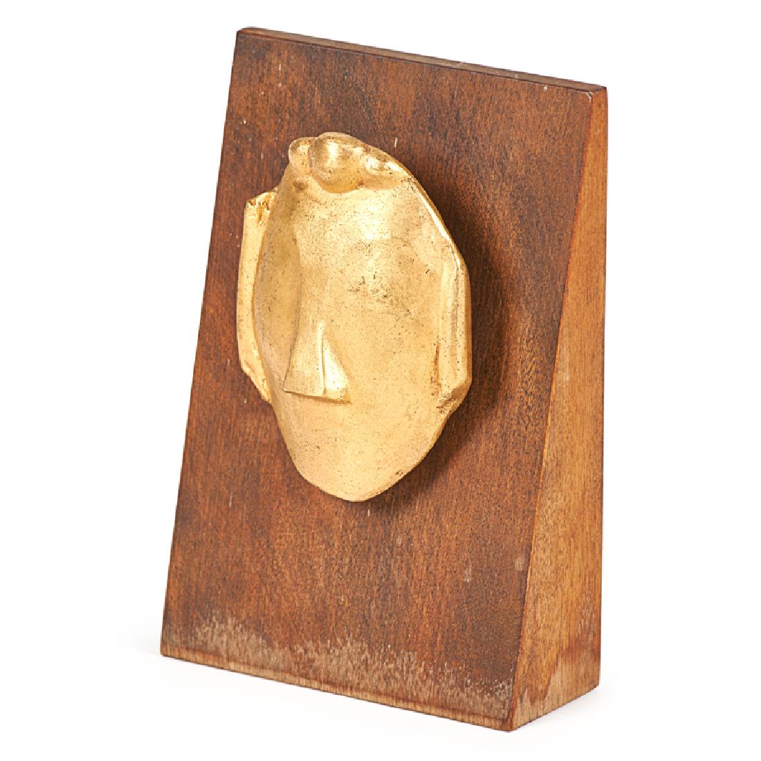 MAX WEBER (American, 1881-1961): "Mask," 1915/1974 Brass with wooden base Signed and numbered 12/47, dated on plaque to verso Publisher: Forum Gallery, NY 6 1/4" x 4 1/4" (overall)