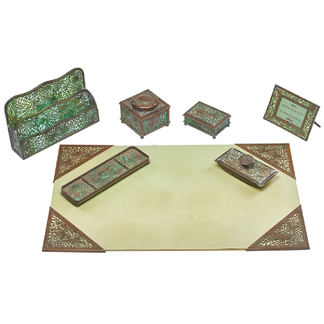 TIFFANY STUDIOS PINE NEEDLE DESK SET: Seven: Letter holder, pen tray, rocker blotter, calendar holder, inkwell, blotter corners with blotter, and utility box, New York, early 20th c. Impressed mark Letter holder: 6" x 10" x 2 1/2"