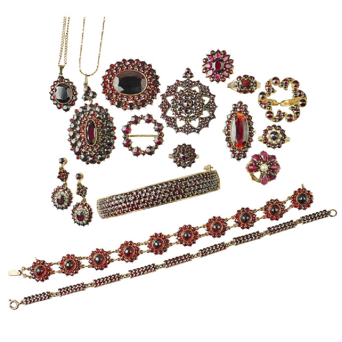 COLLECTION OF BOHEMIAN GARNET JEWELRY: Comprising seven rings, a pair of drop earrings, two pendants on chains, three brooches, two link bracelets and a bangle in gilt silver or yellow gold. 10k-14k. 71.3 dwt. (items with gold). Provenance