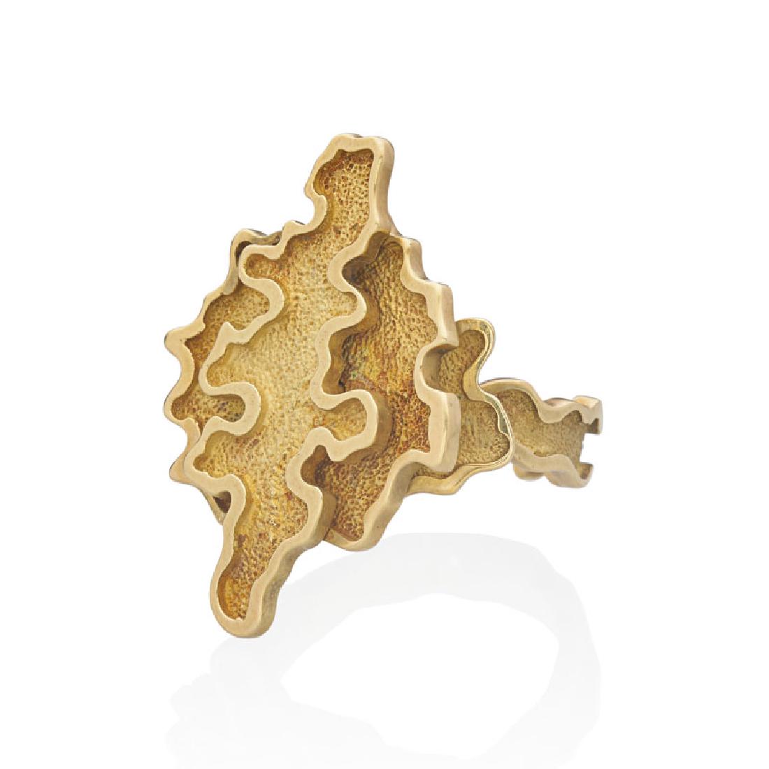 ANDREW GRIMA YELLOW GOLD RING: Designed as layers of freeform textured gold framed by bright gold. 18k. Stamped A. Grima AA 86 with maker's omega mark. Size 8. 9.9 dwt.
