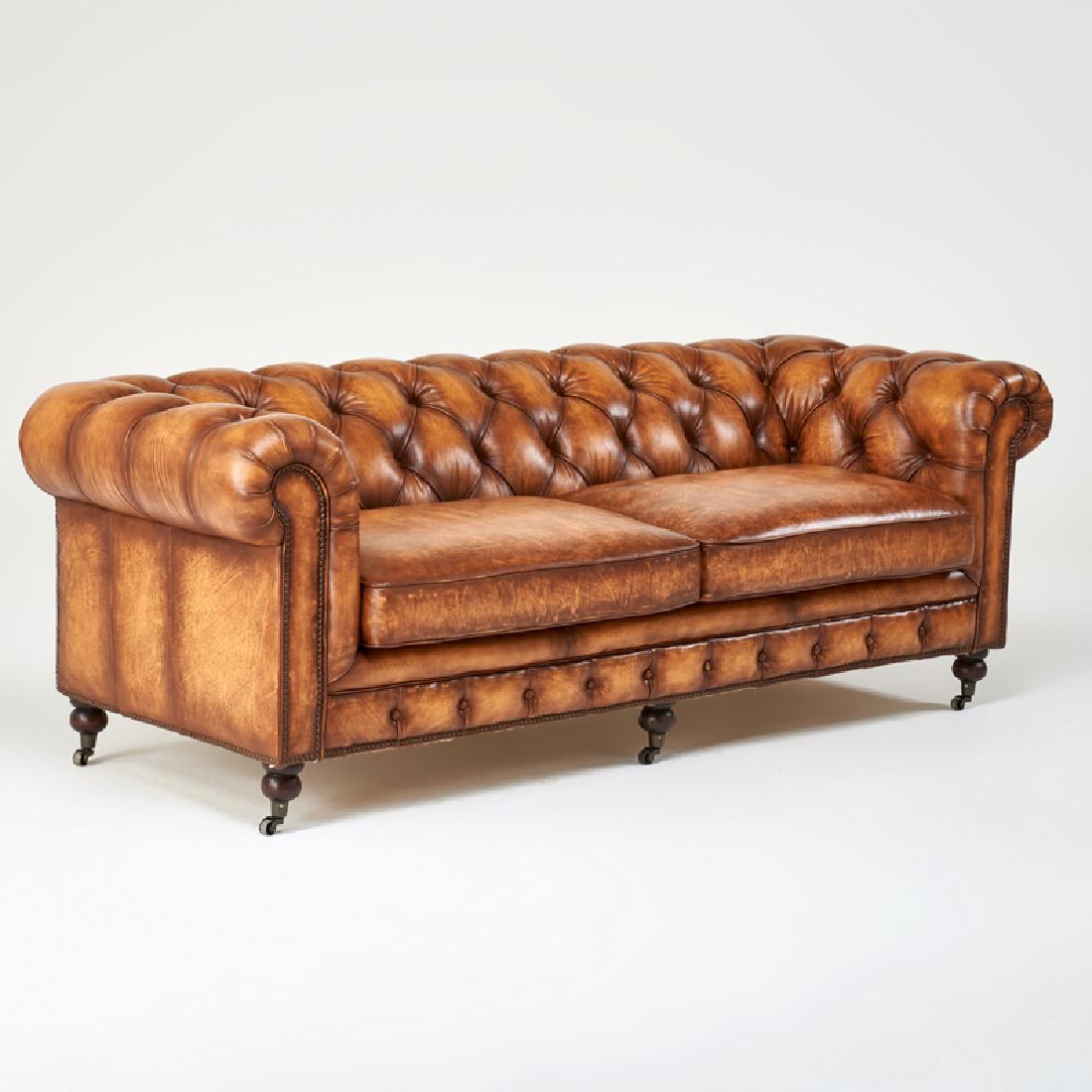 CHESTERFIELD: Sofa, 2000s Turned wood, antiqued brass casters and studs, tufted leather Unmarked 31" x 88" x 40"