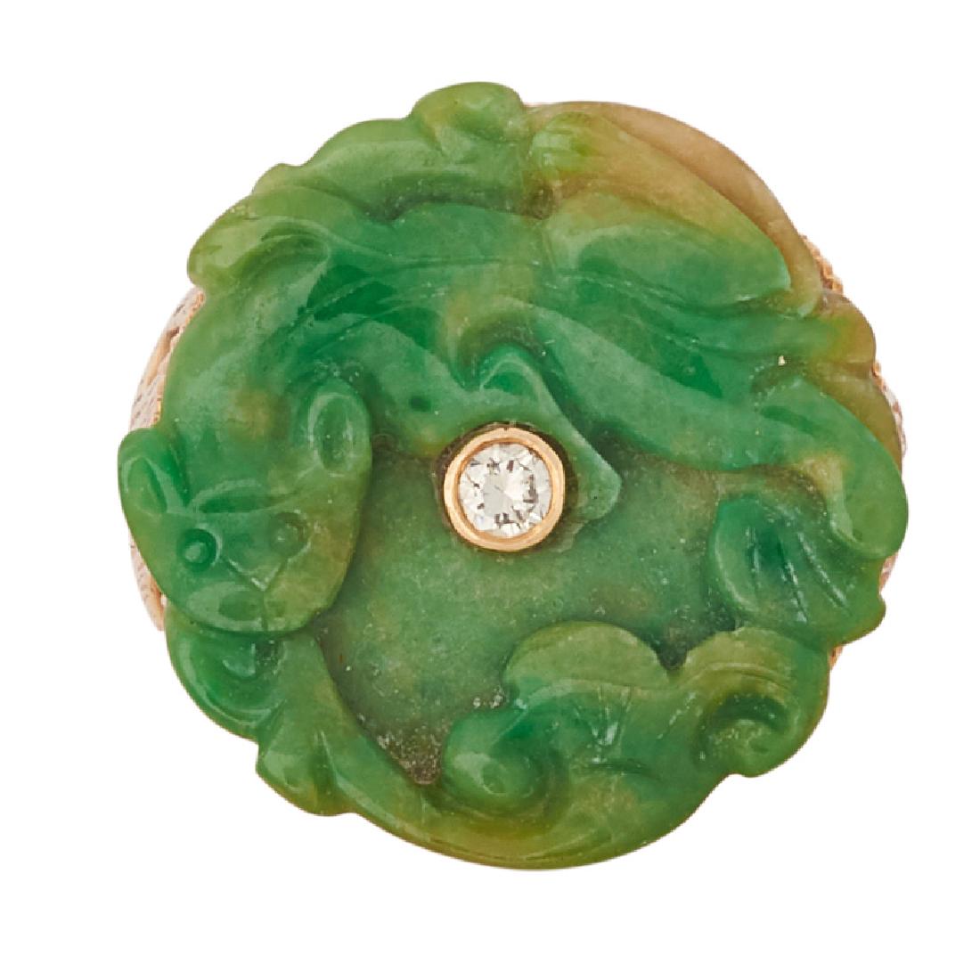 CARVED JADE, DIAMOND & YELLOW GOLD RING: A fire breathing dragon carved jade tablet, bezel set with RBC diamond accent, approx. .04 ct., in elongated pierced and engraved gold gallery. 14k. Size 3 3/4 (with sizing bead). 6.0 dwt.