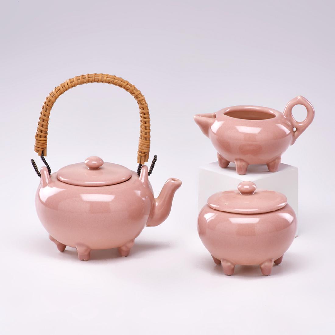 ROOKWOOD: Three-piece production tea set: pot with wicker handle, creamer, and lidded sugar, Cincinnati, OH, 1916 All with flame mark, date, and model Teapot (with handle): 7 1/2" x 6 1/2" dia.