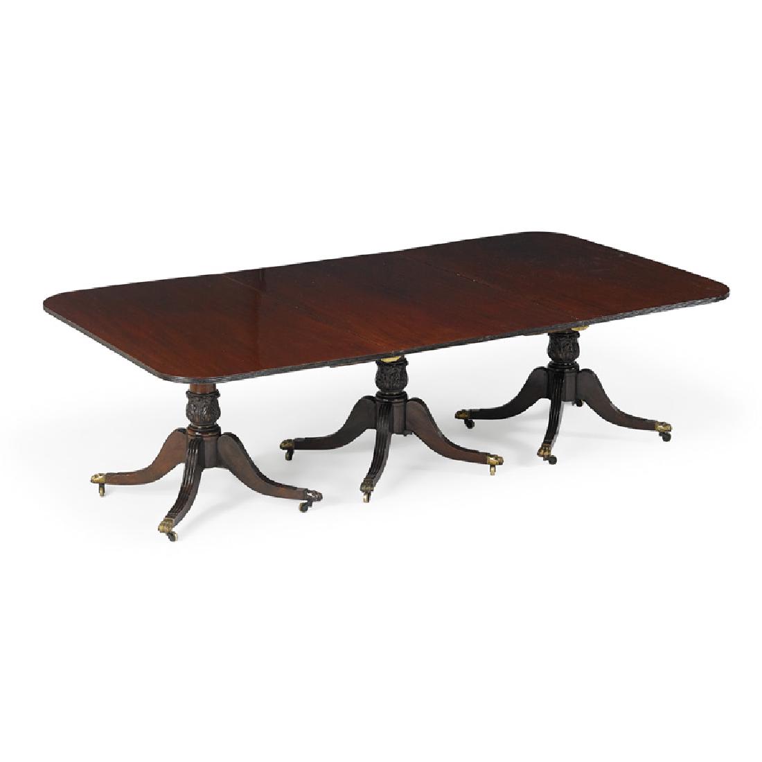 GEORGE III STYLE TRIPLE PEDESTAL DINING TABLE: Each acanthus carved pedestal with reeded sabre legs ending in casters 27" x 53 1/2" x 96"