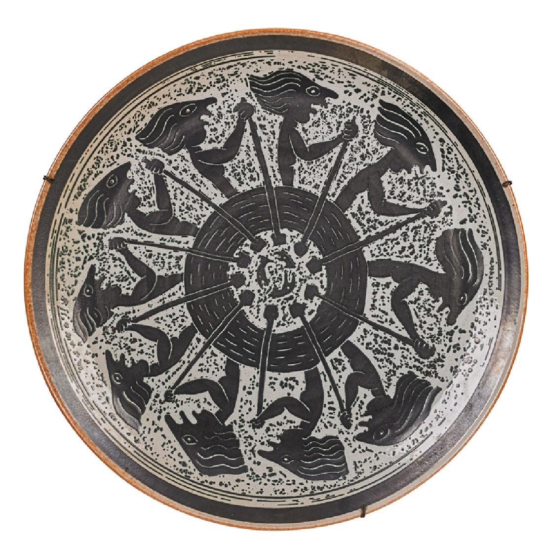 EDWIN AND MARY SCHEIER Large early charger: EDWIN SCHEIER (1910 - 2008) MARY SCHEIER (1908 - 2007) Large early charger with figures in a canoe, 1950s-60s Glazed earthenware Incised Scheier 19" dia. x 2" Complete with a copy of American Potters: