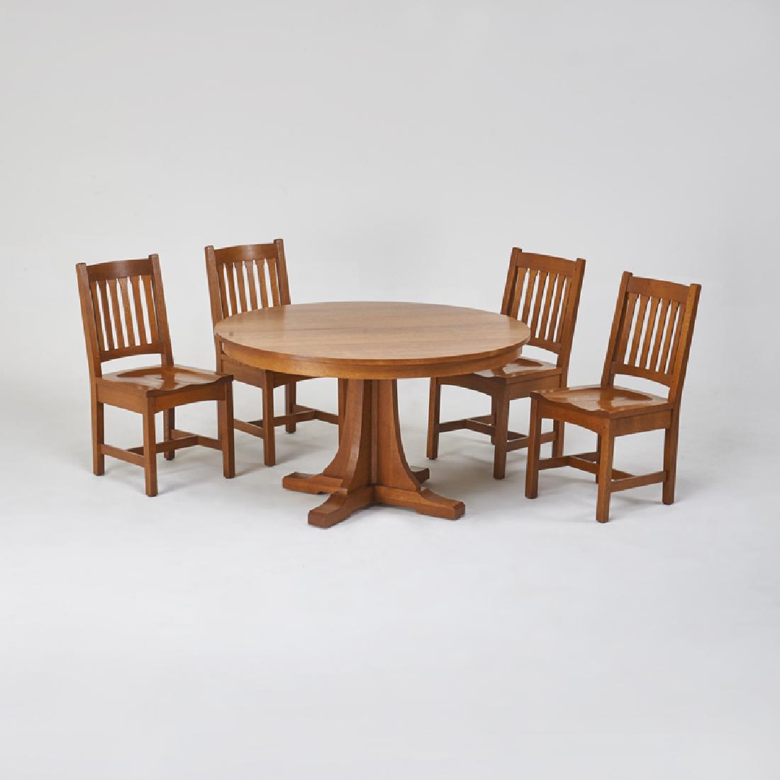 STICKLEY; E.J. AUDI: Contemporary shoe-foot split pedestal dining table and four matching chairs with corseted back-slats, Manlius, NY, 2000s, Quartersawn oak Metal tag, branded mark Table closed: 31" x 52" dia., two 15"