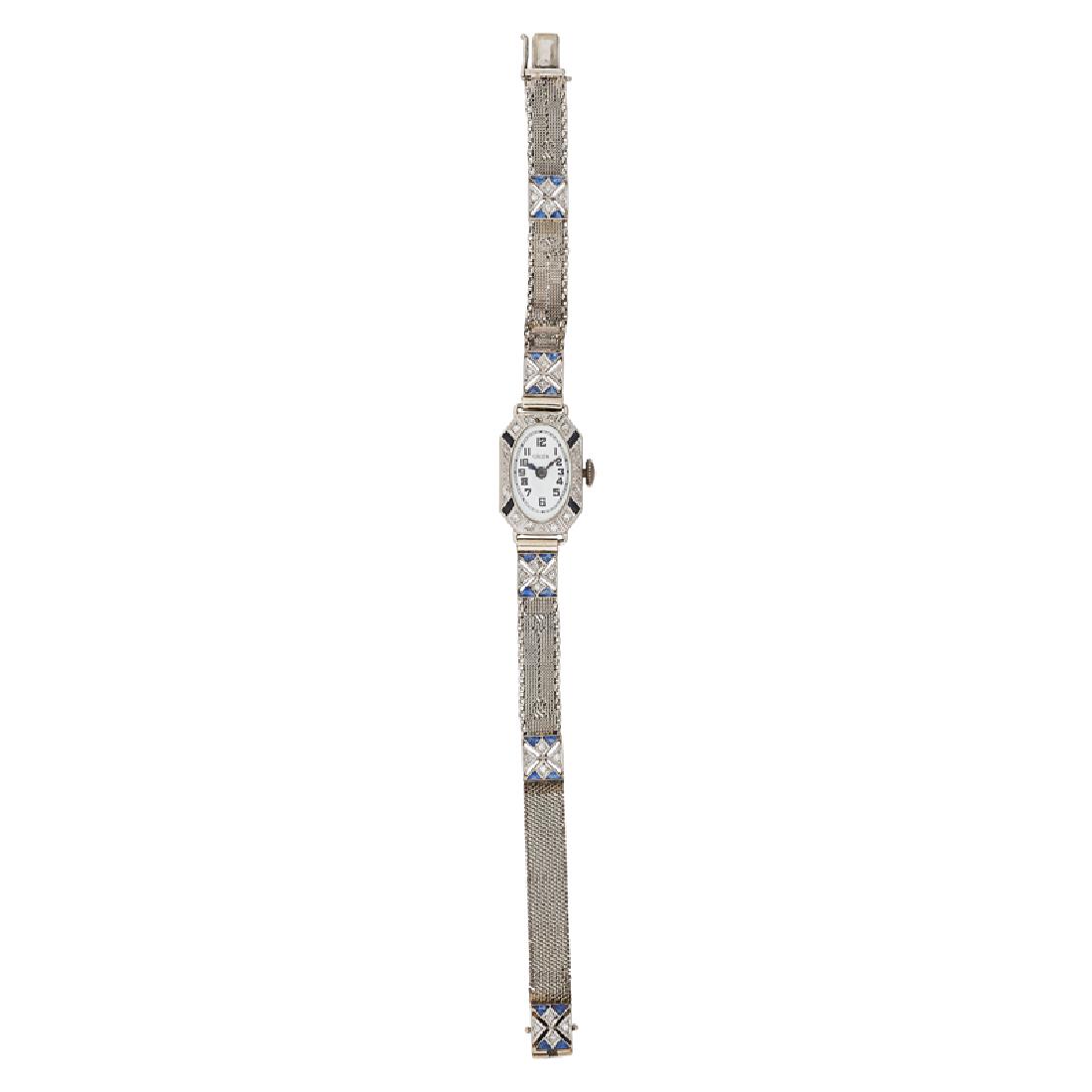 LADY'S GRUEN ART DECO DIAMOND & SAPPHIRE WATCH: The white oval dial with Arabic hours, within single-cut diamond, approx. .32 ct. TW. and calibre-cut sapphire millegrained white gold case, later fifteen-jeweled four adjustment movement, on gold str