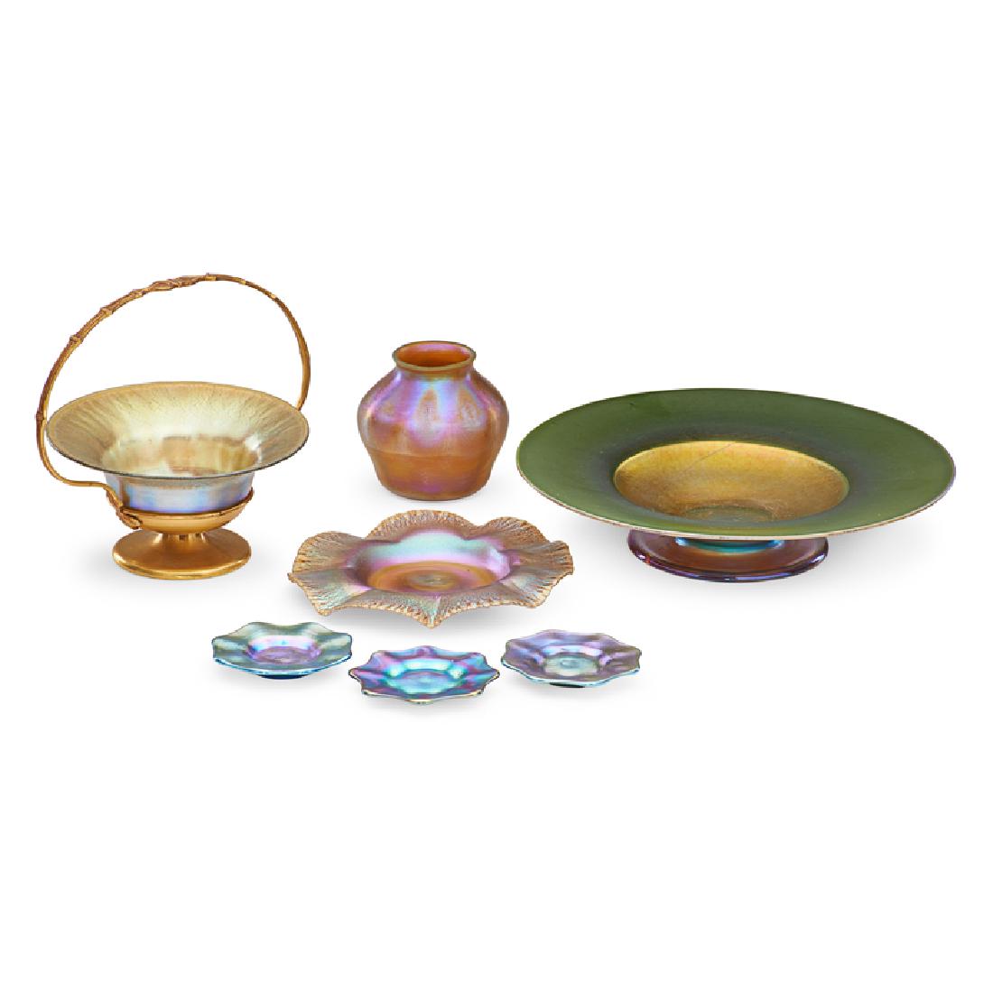 TIFFANY STUDIOS Favrile glass grouping: TIFFANY STUDIOS Favrile glass, New York, early 20th C.: tazza, small vase, ruffled plate, small bowl in metal basket, and three butter pats Blown glass, gilt metal All marked Largest: 2" x 10"