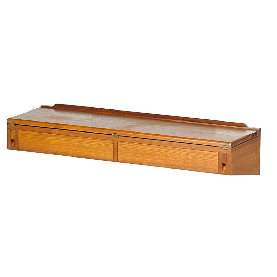 ARNE HOVMAND-OLSEN Wall-hanging flip-top desk: ARNE HOVMAND-OLSEN (1919 - 1989) Wall-hanging flip-top desk, Denmark, 1970s Teak, laminate, brass Manufacturer label 8 1/2" x 40 1/2" x 12", open: 23 1/4"