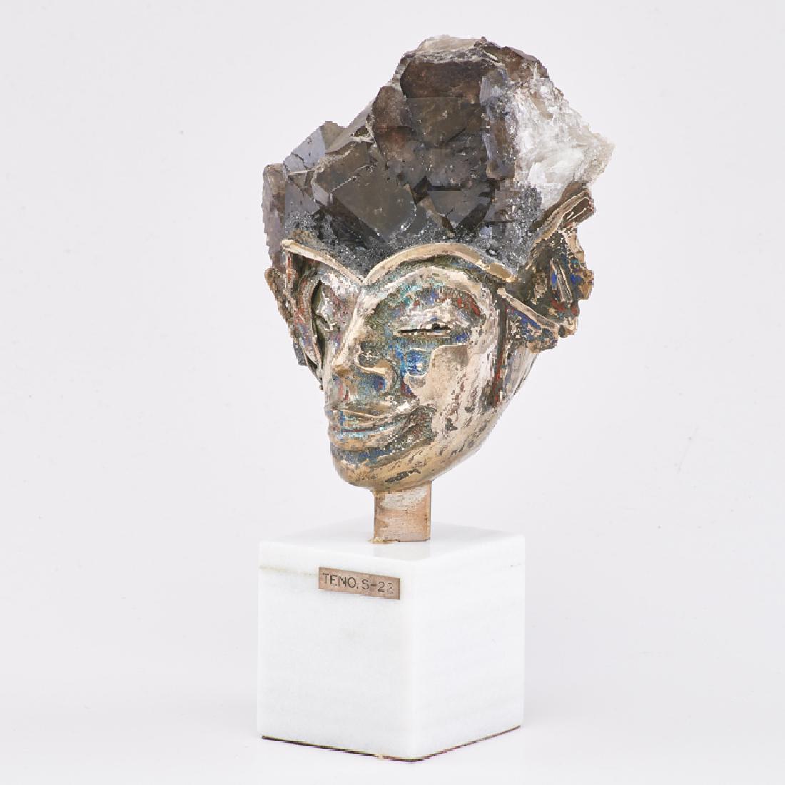 AURELIO TENO (Spanish, 1927-2013): Untitled sculpture (female head), Spain, ca. 1960s/70s Smokey quartz crystal, enameled silver plate, white marble plinth Plaque signed TENO, S-22 10" x 5 1/4" x 3 3/4"