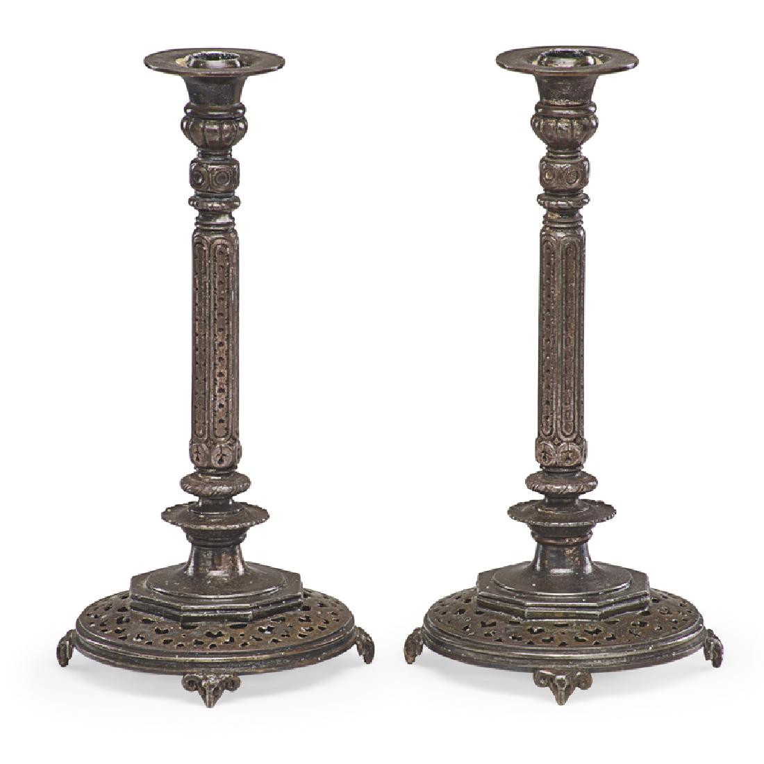 OSCAR BACH PAIR OF CANDLESTICKS: Each with a pierced circular base and rams mask motif, nickel plated bronze, USA, ca. 1925 Signed on metal tag 13" each
