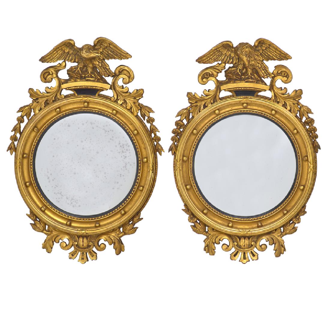 TWO REGENCY STYLE GILTWOOD CONVEX MIRRORS: Each with eagle finials, 20th c. 37" x 22"