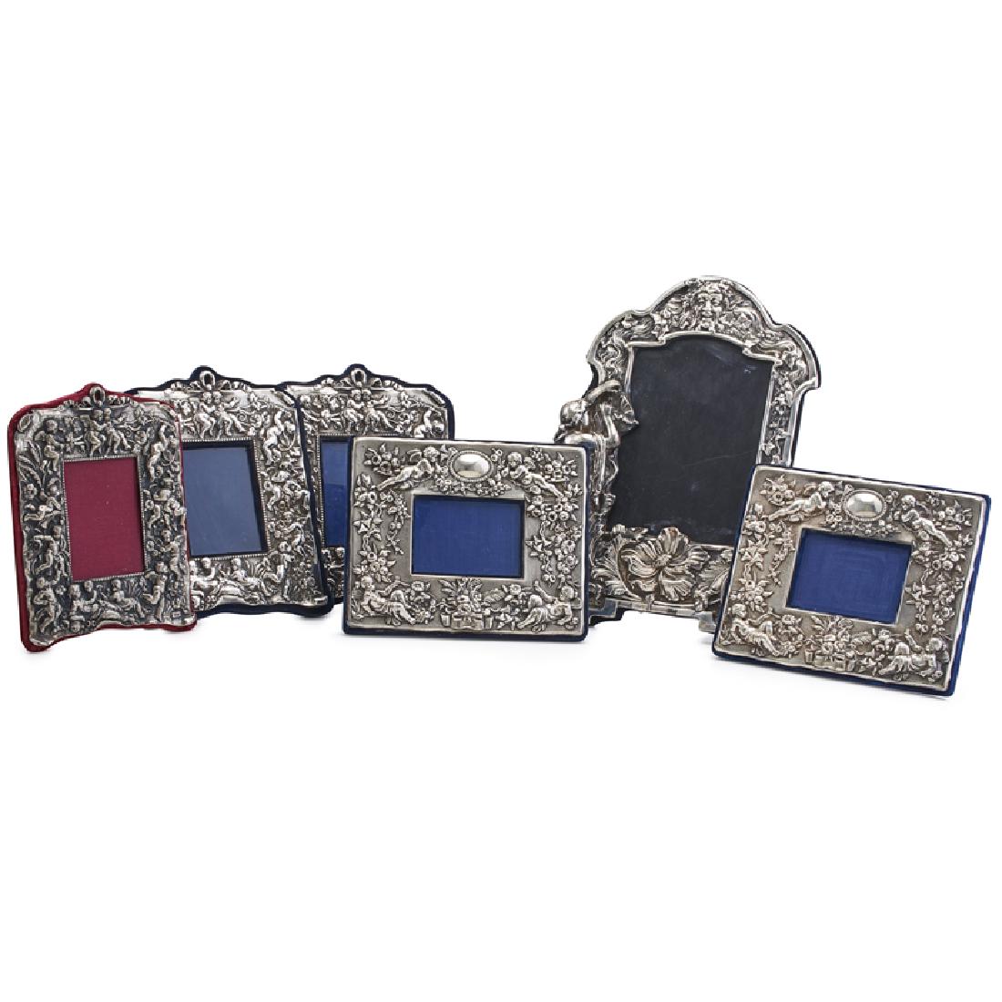 GROUP OF SILVER PICTURE FRAMES: Six: Two pairs of rectangular frames with putti decoration (one pair with spurious English marks, the other marked "sterling"), another rectangular putti decorated frame marked "sterling silver" and a