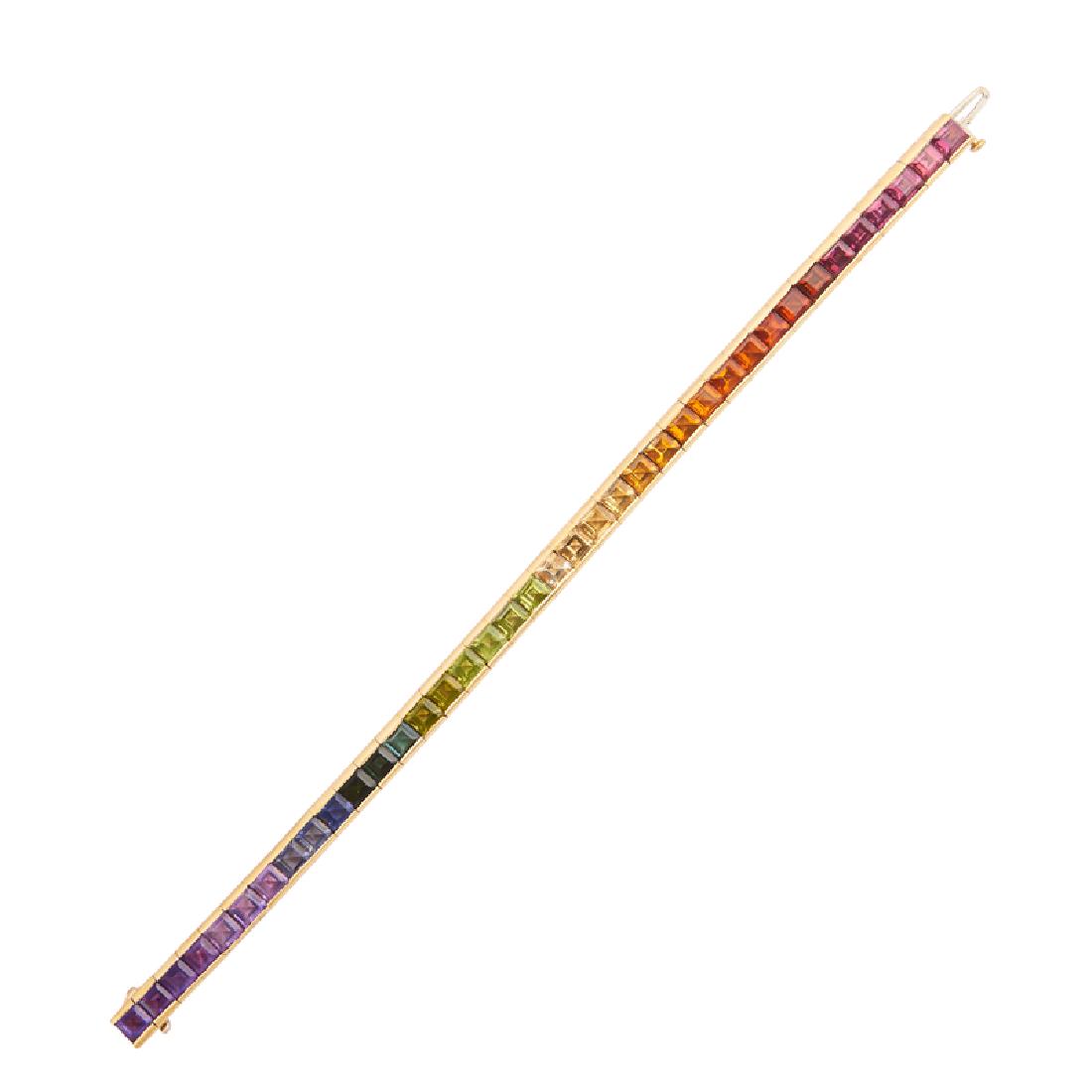 GEM-SET YELLOW GOLD LINE BRACELET: A spectrum of channel-set step-faceted tourmaline, citrine, peridot or amethyst. 18k. 7". 16.7 dwt.