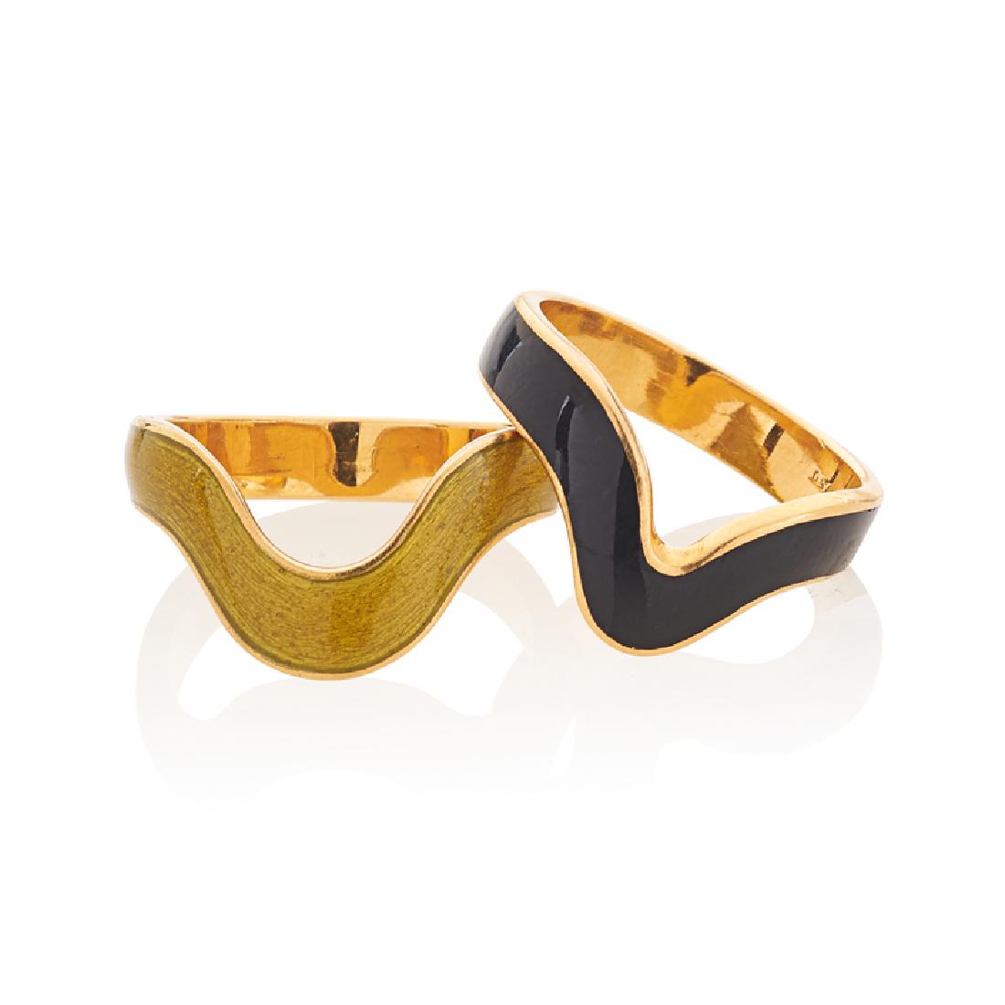 ENAMELED YELLOW GOLD STACKING BAND RINGS: Comprising two black or yellow enameled curvilinear bands. 18k. Size 6. 6.3 dwt.