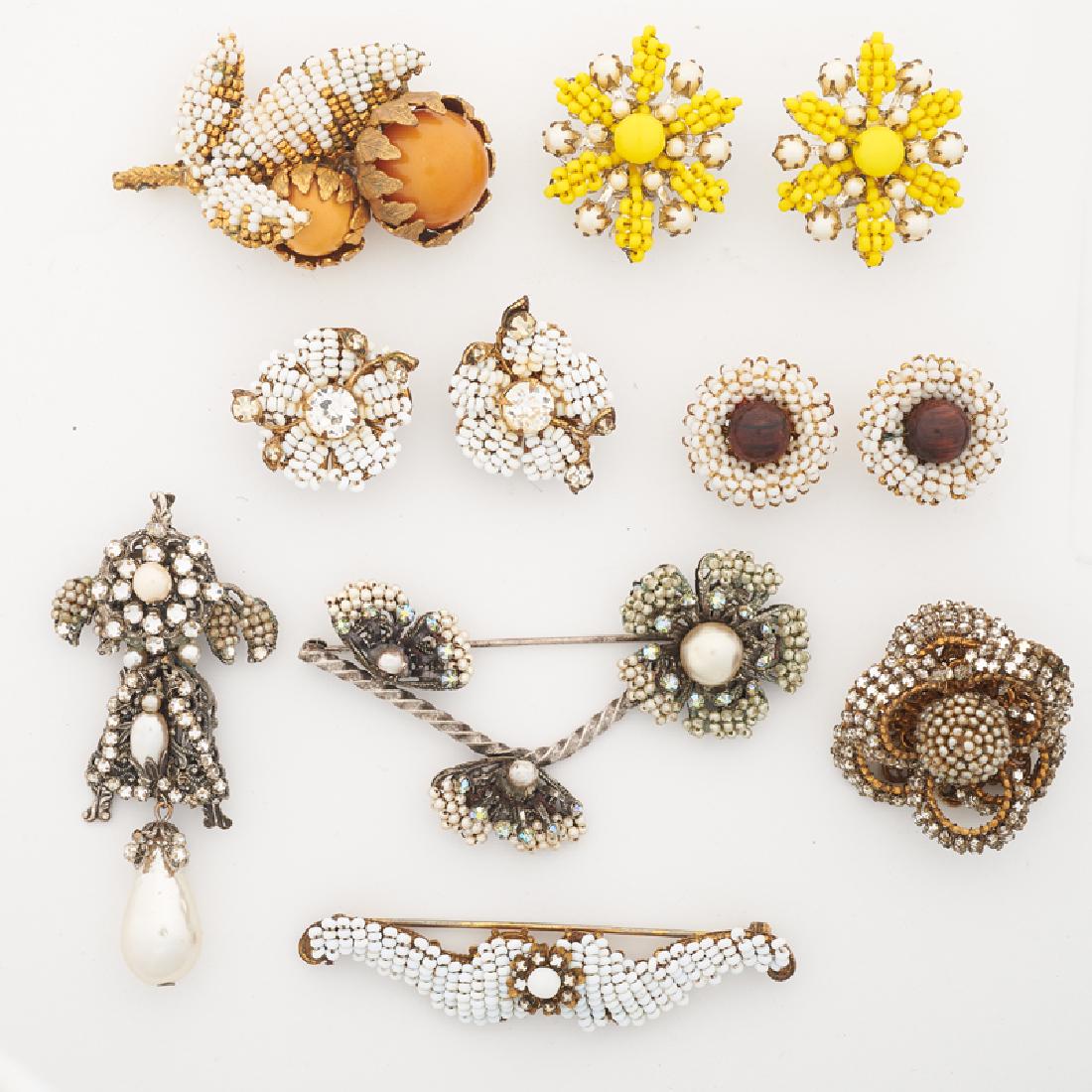 MIRIAM HASKELL IMITATION SEED PEARL COSTUME JEWELRY: Comprising three early ribbon bow, floral or foliate brooches, ca. 1950; A foliate brooch with imitation pearl drop; A bar brooch; Three pairs of earrings with wood, rhinestone or glass bead centers.