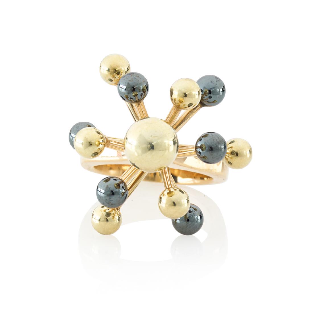 HANS HANSEN HEMATITE & YELLOW GOLD SPUTNIK RING: With carved hematite or bight gold spherical terminals. Ca. 1970. 14k. Stamped by the maker. Size 5. 7.9 dwt.