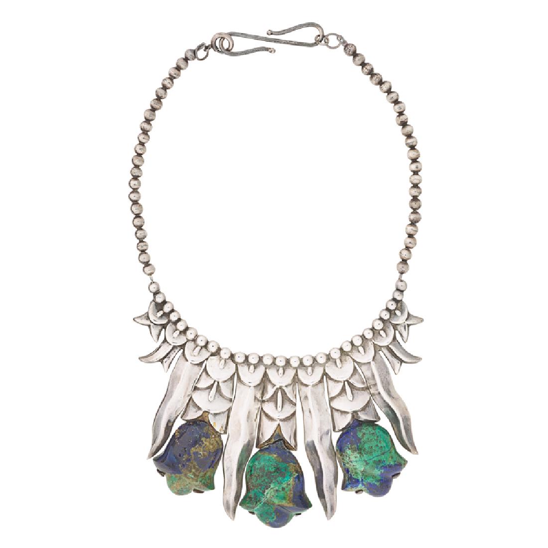 WILLIAM SPRATLING TULIP MALACHITE & SILVER NECKLACE: A carved malachite tulip and bright silver leaf bib, suspends from a strand of beads. 1940-1946. Stamped by the maker. 16", 2 3/4" drop. 150.2 gs. GW.