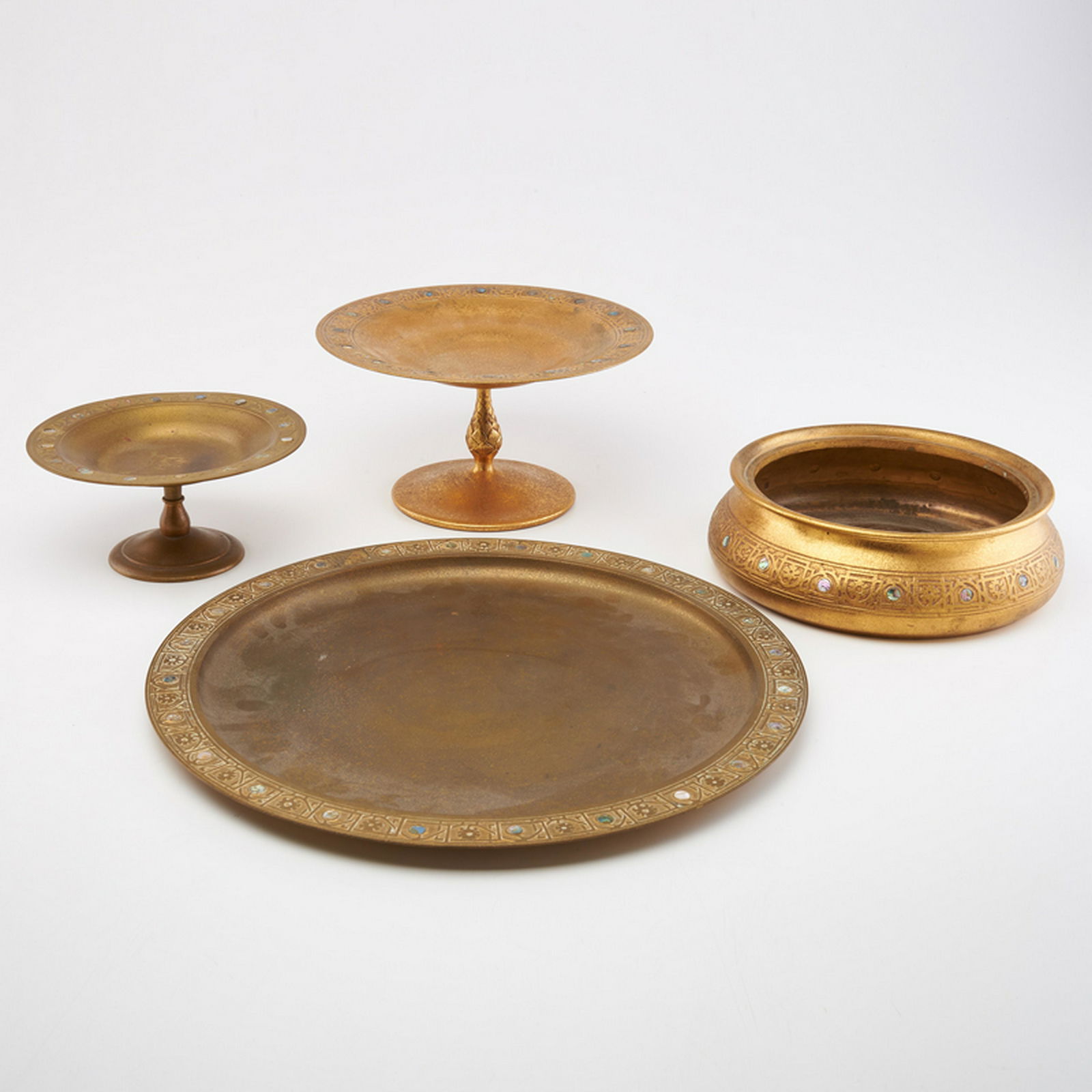 TIFFANY STUDIOS: Four pieces: Abalone pattern tray (14" dia.), planter (2 3/4" x 8 3/4" dia.), footed compote with artichoke stem (4 7/8" x 8 7/8" dia.), and smaller footed compote (3 1/4" x 6 3/4" dia.), New York, 20