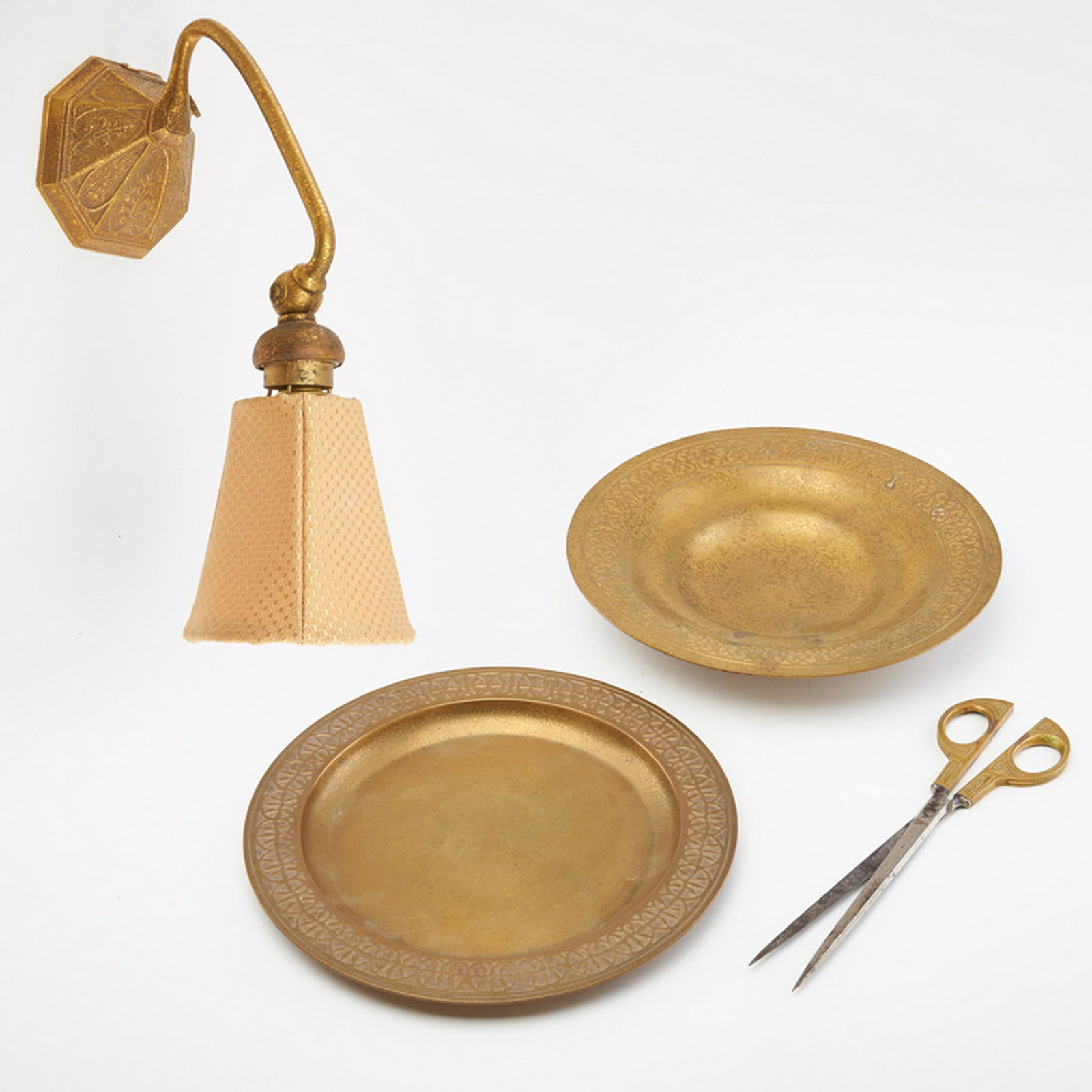 TIFFANY STUDIOS: Four pieces: miniature desk lamp (6 3/4" x 4" x 10 1/2"), scissors in the Graduate pattern (9"), card tray with Moorish band decoration (1 1/2" x 9" dia.), and tray with geometric band decoration (1/4